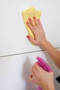 Woman cleaning white surface in the kitchen at home