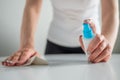 Woman cleaning white table with wet wipe - disinfection concept