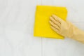 Woman cleaning tiles with yellow cloth