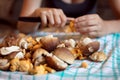 Woman cleaning wild mushrooms in the kitchen, porcini and chanterelles