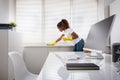 Woman Cleaning The Window Sill In Office