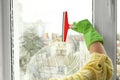 Woman cleaning window with squeegee, closeup Royalty Free Stock Photo