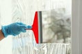 Woman cleaning window with squeegee, closeup Royalty Free Stock Photo