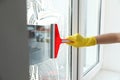 Woman cleaning window with squeegee, closeup Royalty Free Stock Photo