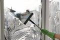 Woman cleaning window with squeegee, closeup Royalty Free Stock Photo