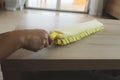 Woman cleaning and wiping the table with microfiber cloth duster in the living room. Woman doing chores at home. Royalty Free Stock Photo