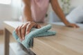 Woman cleaning and wiping the table with microfiber cloth in the living room. Woman doing chores at home. Royalty Free Stock Photo