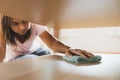 Woman cleaning and wiping the table with microfiber cloth in the living room. Woman doing chores at home. Royalty Free Stock Photo