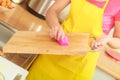 Woman cleaning wooden cutting board with rag Royalty Free Stock Photo