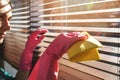 Woman cleaning wooden window blinds from dust at home