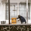 A woman cleans an empty store front on the streets of Tbilisi - GEORGIA - Capital City Beauty