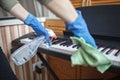 Woman cleans home  wipes dust from the piano and dreams about music  authentic inner life Royalty Free Stock Photo