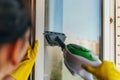 Woman cleans window glass with steam device from dirt