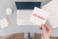 Woman clerk sitting holding note paper sticker with new member phrase. Business concept. Royalty Free Stock Photo