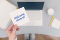 Woman clerk sitting holding note paper sticker with welcome aboard phrase. Business concept.