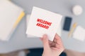 Woman clerk sitting holding note paper sticker with welcome aboard phrase. Business concept. Royalty Free Stock Photo