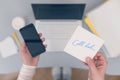 Woman clerk is sitting at office table holding note sticker with message call dad.