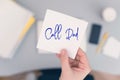 Woman clerk is sitting at office table holding note sticker with message call dad