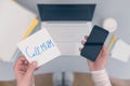 Woman clerk is sitting at office table holding note sticker with message call mum