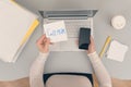 Woman clerk is sitting at office table holding note sticker with message call mum