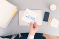 Woman clerk is sitting at office table holding note sticker with message call mum