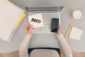 Woman clerk sitting at the office table and holding note sticker with word boss and the phone.