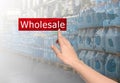 Woman clicking Wholesale button and world map with blurred view of warehouse