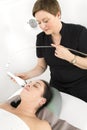 Woman client gets face slimming treatment at beauty clinic