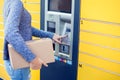 Woman using automated self service post terminal machine or lock