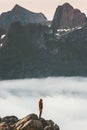 Woman on cliff edge over clouds travel in mountains Royalty Free Stock Photo