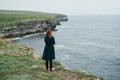 Woman on the cliff of the mountain by the sea, sadness, wind Royalty Free Stock Photo