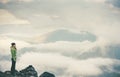 Woman on cliff traveling enjoying cloudy foggy mountains