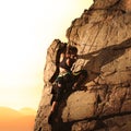 Woman Climber Climbing to the Top of the Rock at Foggy Sunset in the Mountains. Adventure and Extreme Sport Concept Royalty Free Stock Photo