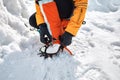 Woman climber in ice crampons near frozen waterfall