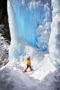 Woman climber near frozen waterfall in the mountains