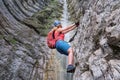 Woman climber on via ferrata next to waterfall, in Italy, Europe. Summer adventure extreme activities Royalty Free Stock Photo