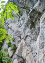 Woman climbing impressive rock formations on difficult via ferrata route called Zimmereben, near Mayrhofen, Zillertal valley