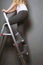 Woman climbing ladder in socks Royalty Free Stock Photo