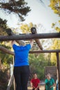 Woman climbing monkey bars during obstacle course training in the boot camp Royalty Free Stock Photo