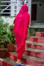 Woman climbing stairs on her back, dressed in a sari, in India