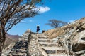 Woman climbing stairs to desert fortress