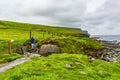 Woman climbing a stone ladder on a rainy day on the coastal walk route from Doolin to Cliffs of the Moher Royalty Free Stock Photo