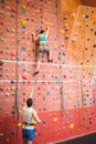 Woman climbing up rock wall Royalty Free Stock Photo