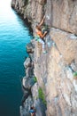 A woman climbs the rock.