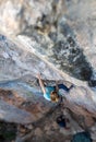 A woman climbs a rock