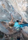 A woman climbs a rock