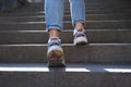Woman climbs stairs to street closeup. Daily walks and healthy lifestyle