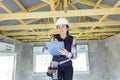 woman with clipboard inspecting beams in newbuild property