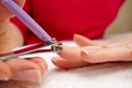 Woman Clipping Nail s with Forceps. Female cuts his nails on a white background with tweezers for nails. manicure procedures Royalty Free Stock Photo