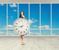 Woman with clock in empty room Royalty Free Stock Photo